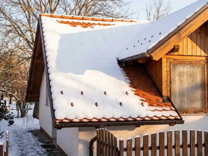 Obiteljska kuća prekrivena snijegom s novim krovom od crijepa na kojem su snjegobrani - Krovopokrivač Đakovo - IP BAU