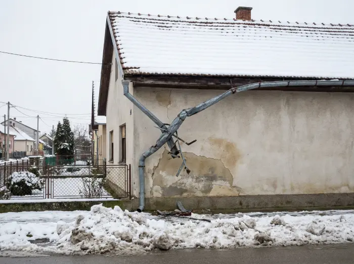 Ugradnja snjegobrana na krov: Vrste, ugradnja i zašto su zimi obavezni? 2 Potpuno savinut i oštećen metalni oluk na fasadi uzrokovan naglim padom snježne lavine s krova - Krovopokrivač Đakovo - IP BAU